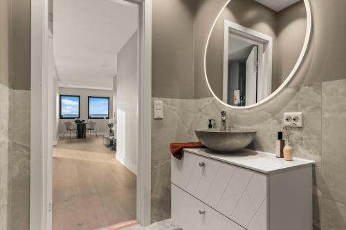 a bathroom with a sink and a mirror on the wall at Exclusive Oslo Fjord Apartment in Oslo