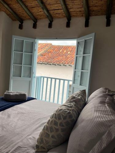 a bedroom with a bed and an open door at Encanto Azul in Villa de Leyva