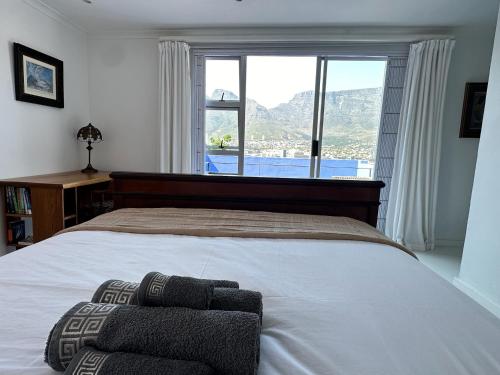 a bedroom with a large bed with a large window at Casa Finchette rooftop apartment with panoramic views of Table Mountain in Cape Town