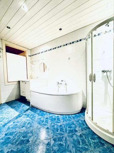 une salle de bain avec baignoire et sol bleu dans l'établissement Cozy 4BR Apt for up to 12P 10-Min to FAC Platz, à Vienne