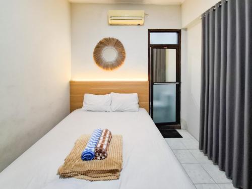a bedroom with a bed and a mirror on the wall at Hotel Djaya RedPartner near Alun Alun Nganjuk in Nganjuk