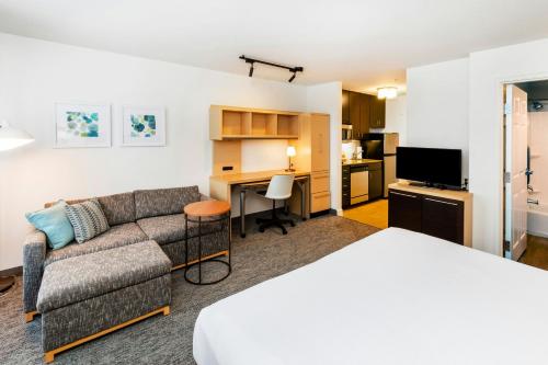 a hotel room with a bed and a couch and a desk at TownePlace Suites by Marriott Tulsa Broken Arrow in Broken Arrow