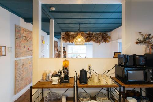 a room with a table with a microwave and a coffee maker at Guest House Waya in Sapporo