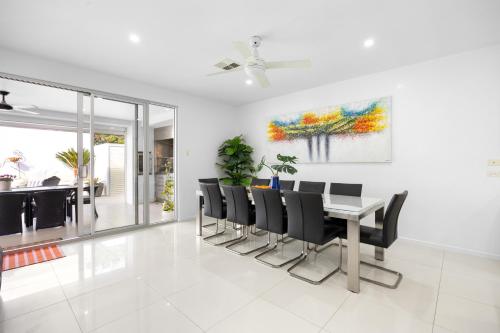 a dining room with a table and black chairs at Parea on Cavendish - Luxe Beachside Living in West Beach