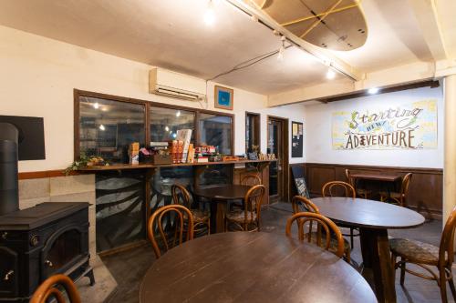 a restaurant with tables and chairs and a bar at Guest House Waya in Sapporo