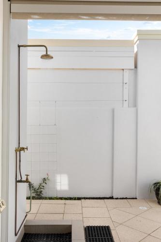 a shower in a bathroom with a white wall at Parea on Cavendish - Luxe Beachside Living in West Beach