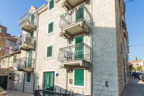 a building with green shutters and balconies on it at Split Center Apartments in Split