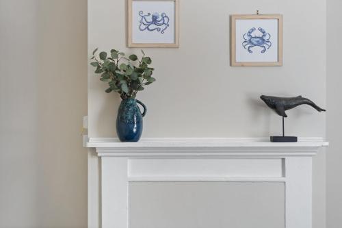 a white fireplace with a vase of flowers on it at Wonderful William - Charming Home close to CBD in Bathurst