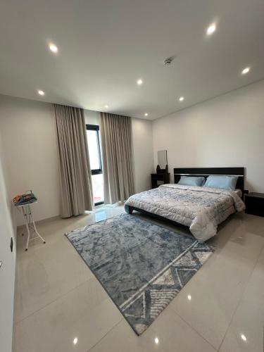 a bedroom with a large bed and a rug at Sea & Lagoon View in The Wave in Muscat