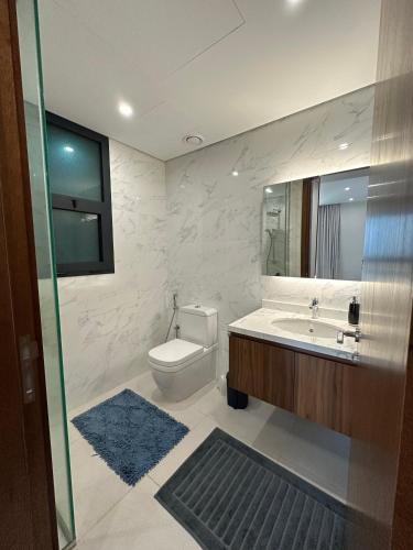 a bathroom with a toilet and a sink and a mirror at Sea & Lagoon View in The Wave in Muscat