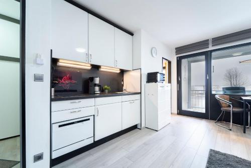 a kitchen with white cabinets and a large window at Mija in Süssau