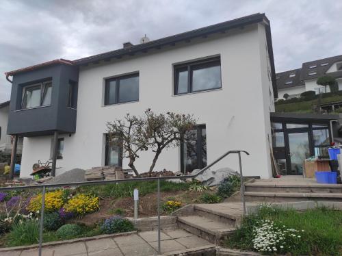 a white house with a garden in front of it at Ferienwohnung Traumblick in Bretzfeld