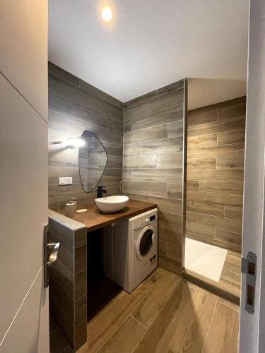 une salle de bain avec une machine à laver et un lavabo dans l'établissement Appartement Terrasse, à Porto-Vecchio