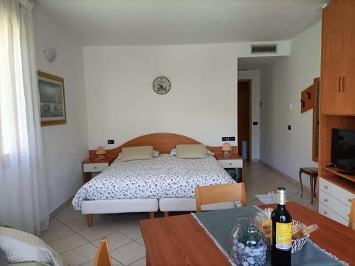 a bedroom with a bed and a dining table at G&B Apartments in Tignale
