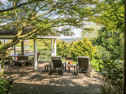 Un patio con sillas y una mesa en una terraza. en Frog Meadow Barn, en Biddulph