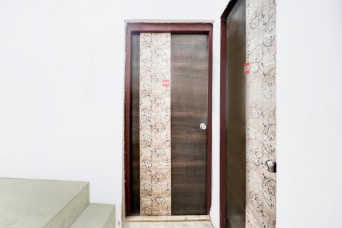 porta in legno in camera con scale di Hotel O Deluxe United Corporate Home a Airoli