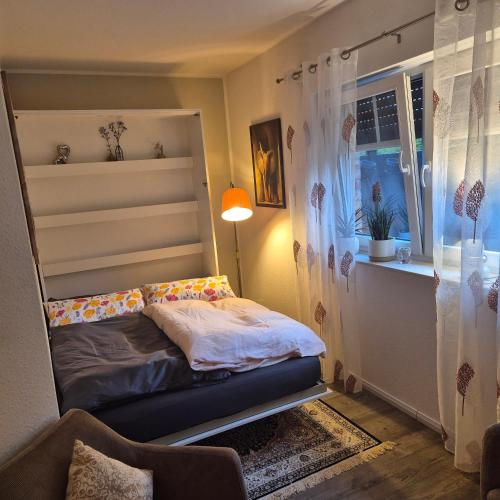 a small bedroom with a bed and a window at fewo-aller-auszeit in Hademstorf