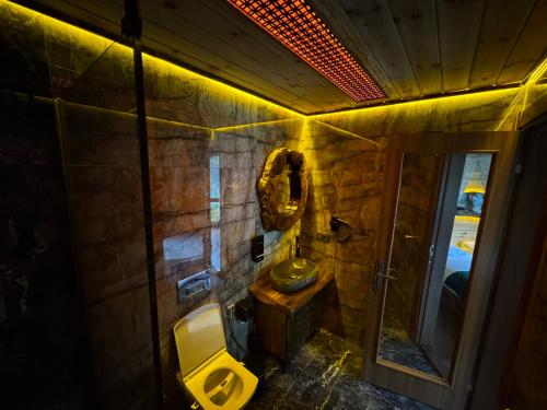 a bathroom with a sink and a toilet and a mirror at Navi Suit Pansiyon in Çamlıhemşin
