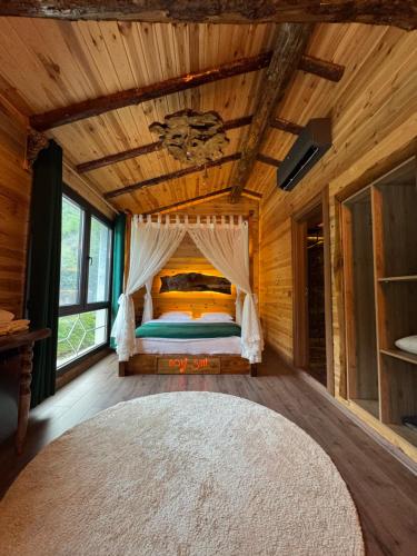 a bedroom with a bed in a wooden cabin at Navi Suit Pansiyon in Çamlıhemşin