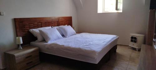 a bedroom with a large bed with white sheets and pillows at Statek Kloubek in Chabičovice
