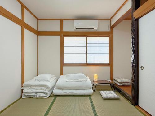 a room with two beds in it with a window at NewDayHouse日式洋房独栋最多住10人 新今宫站近温泉通天阁天王寺 机场直达 半小时到世博会 in Osaka