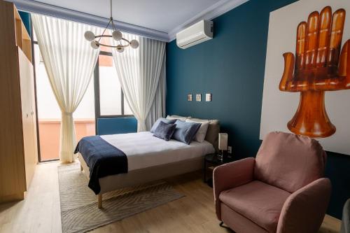 a bedroom with a bed and a chair at Chihuahua Boutique Centric Studio & Loft in Mexico City