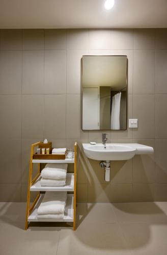 a bathroom with a sink and a mirror and towels at ibis Melbourne Central in Melbourne