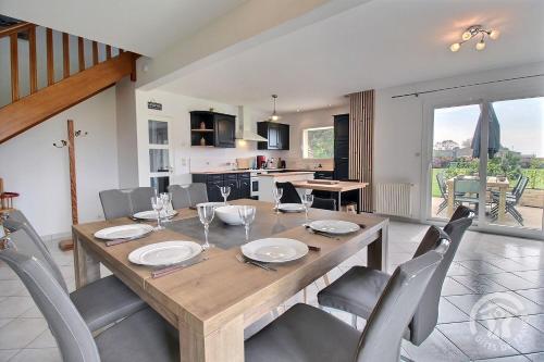 une salle à manger avec une table et des chaises en bois dans l'établissement Ty camille, à Ploubazlanec