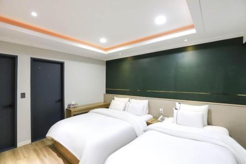 two beds in a room with a chalkboard on the wall at Hotel Primo Daejeon in Daejeon