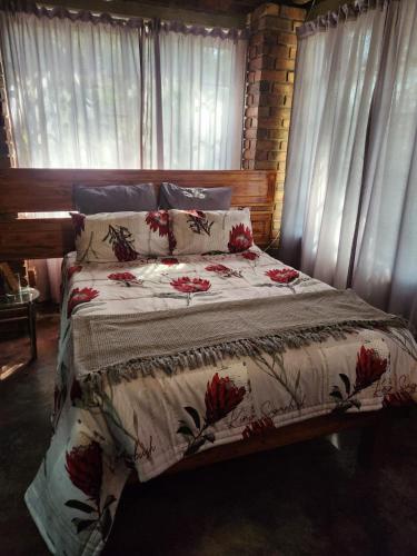 a bedroom with a bed with red flowers on it at Kudu Mal in Marloth Park