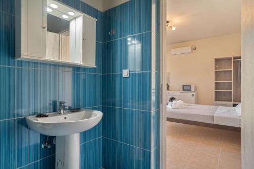 a bathroom with a sink and a bed at Panagis Apartments in Argostoli