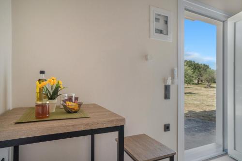 a kitchen with a table with flowers and a door at Panagis Apartments in Argostoli