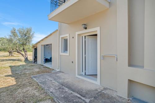 an exterior view of a white building with an open door at Panagis Apartments in Argostoli