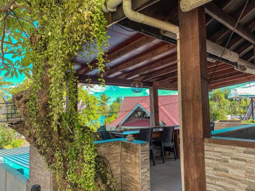 a patio with a table and a tree at Divers Lodge Guest House in Beau Vallon