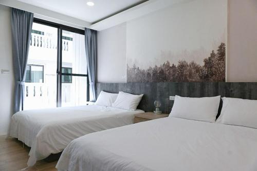 Un dormitorio con dos camas y una gran ventana. en 枕123民宿 宜蘭包棟民宿 依人數開房, en Yilan City
