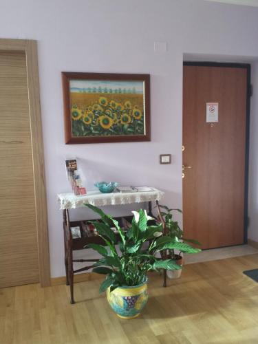 a room with a table and a plant and a painting at Garden B&B in Arezzo