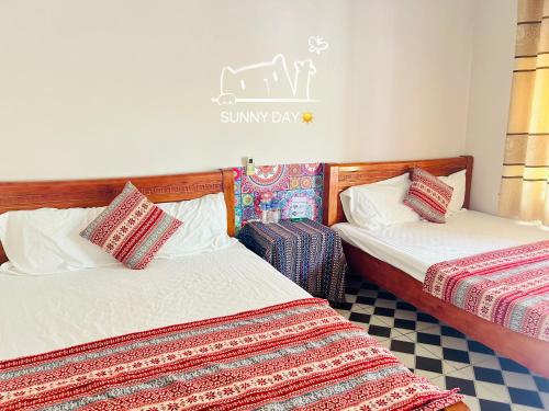 a room with two beds and a sign that reads sunny day at Cô Tô Lương Chi in Quang Ninh