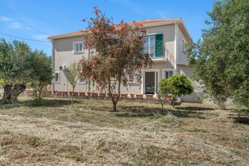 an image of a house with trees in front of it at Panagis Apartments in Argostoli