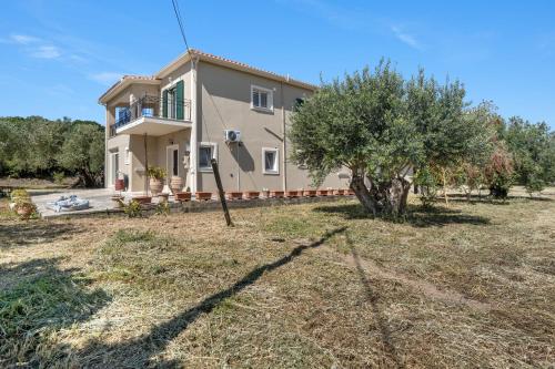 a large house with a tree in the yard at Panagis Apartments in Argostoli