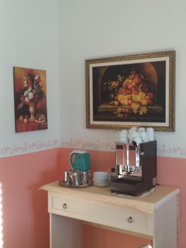 a table with a coffee maker and a painting on the wall at Garden B&B in Arezzo
