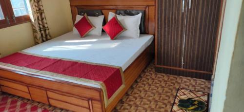 a bedroom with a bed with red and white pillows at Sejal Homestay in Shimla