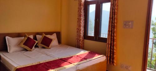 a bedroom with a bed with pillows and a window at Sejal Homestay in Shimla