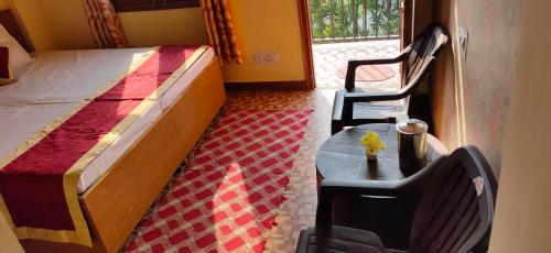 a bedroom with a bed and a table and a chair at Sejal Homestay in Shimla