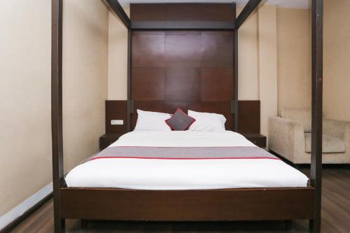 a bedroom with a bed with a wooden headboard at Collection O Cikarang Near Pollux Mall Formerly Hotel Pesona Cikarang in Cikarang