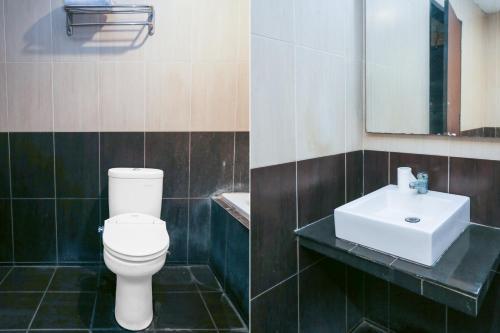 a bathroom with a white toilet and a sink at Collection O Cikarang Near Pollux Mall Formerly Hotel Pesona Cikarang in Cikarang