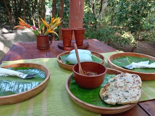a table with bowls and plates of food on it at Dambulla Tree House in Dambulla