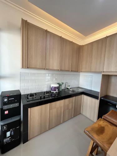a kitchen with wooden cabinets and a stove top oven at Homestay Tjokro by Sampai in Gandok