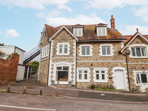 a large brick house with white windows on a street at Sea Haven in Seaton