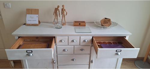 une commode blanche avec des tiroirs et une table avec un ordinateur portable dessus dans l'établissement 103m2 d'Espace et de Calme au coeur de Montpellier, à Montpellier