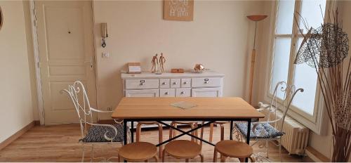 une salle à manger avec une table et des chaises en bois dans l'établissement 103m2 d'Espace et de Calme au coeur de Montpellier, à Montpellier